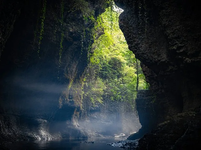 Sunlight piercing through misty rocky gorge in Martvili Canyon