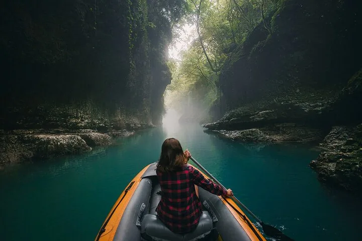 Personne pagayant dans un bateau gonflable sur une rivière à travers une gorge
