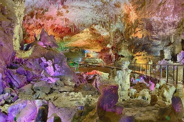Stalactites et stalagmites colorées à l'intérieur de la grotte de Prométhée illuminée